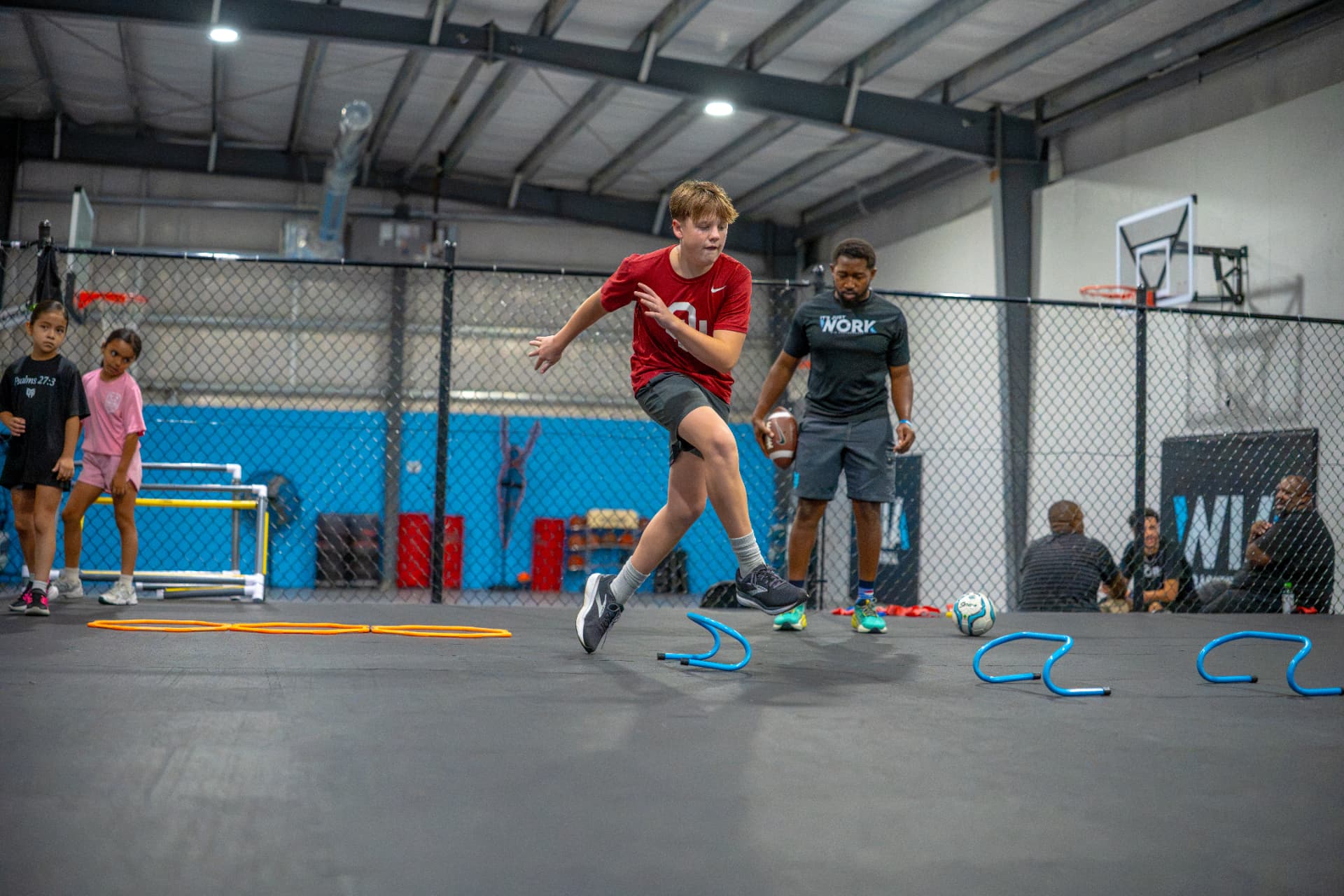 WIA athlete completing a hurdle drill with a coach
